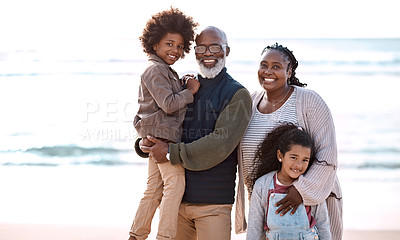Buy stock photo Shot of an adorable little boy and girl spending time with their grandparents at the beach