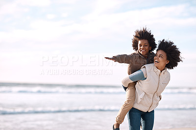 Buy stock photo Shot of an adorable little boy having a fun day at the beach with his mother