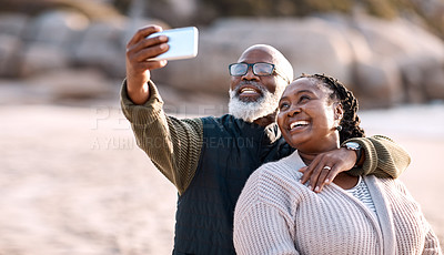 Buy stock photo Shot of a happy mature couple taking selfies with a smartphone at the beach