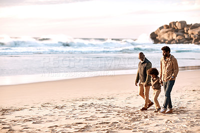 Buy stock photo Shot of an adorable little boy going for a walk along the beach with his grandfather and father