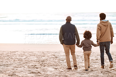 Buy stock photo Rearview shot of an adorable little boy spending time at the beach with his grandfather and father