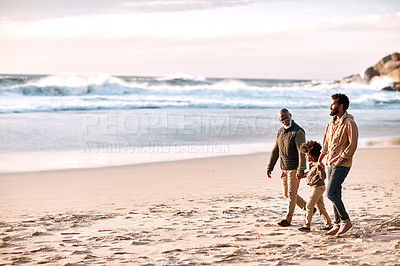 Buy stock photo Shot of an adorable little boy going for a walk along the beach with his grandfather and father