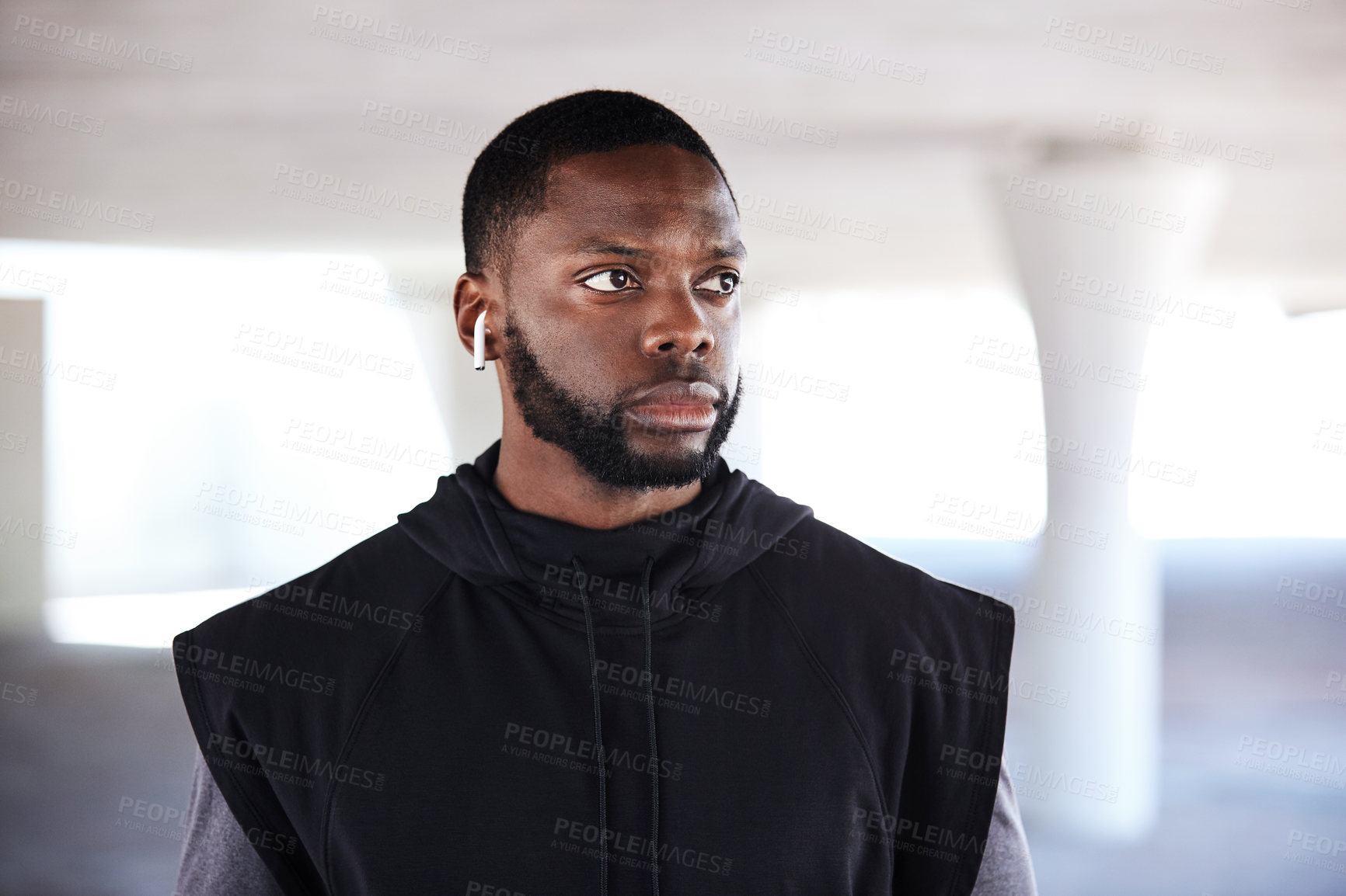 Buy stock photo Fitness, athlete and man with earphones in city, think and streaming music after exercise or health. Outdoor, runner and black person with tech post workout, serious and listening to song on break
