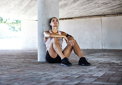 Buy stock photo Full length shot of an attractive young female athlete taking a rest while working out in the city