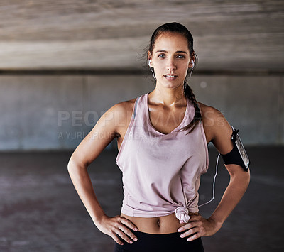 Buy stock photo Cropped portrait of an attractive young female athlete standing with her hands on her hips while working out in the city