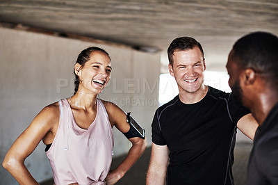 Buy stock photo Cropped shot of three young athletes talking while working out in the city