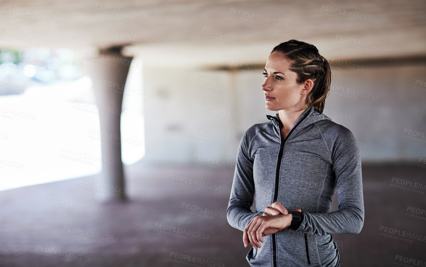Buy stock photo Cropped shot of an attractive young female athlete checking her watch while working out in the city