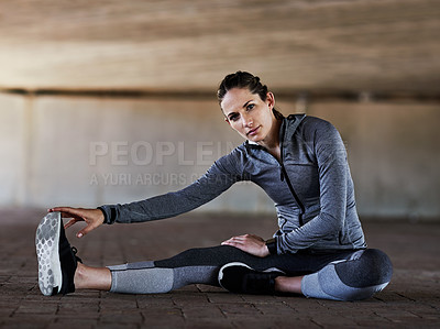 Buy stock photo Full length portrait of an attractive young female athlete stretching during her workout in the city