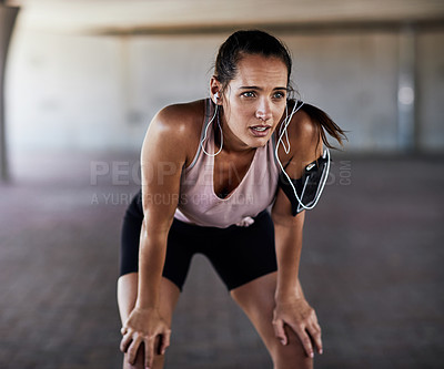 Buy stock photo Cropped shot of an attractive young female athlete resting during her workout in the city
