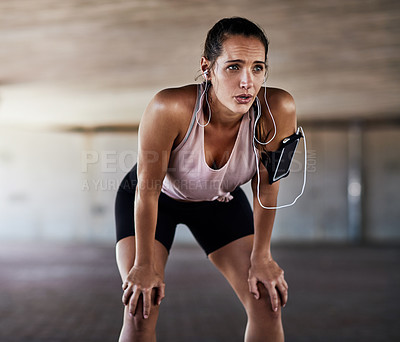 Buy stock photo Cropped shot of an attractive young female athlete resting during her workout in the city
