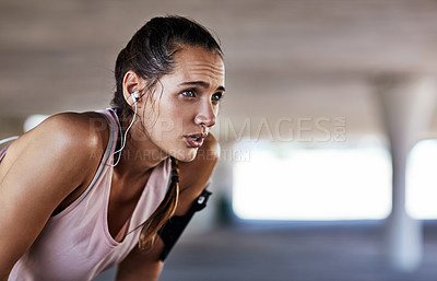 Buy stock photo Cropped shot of an attractive young female athlete resting during her workout in the city