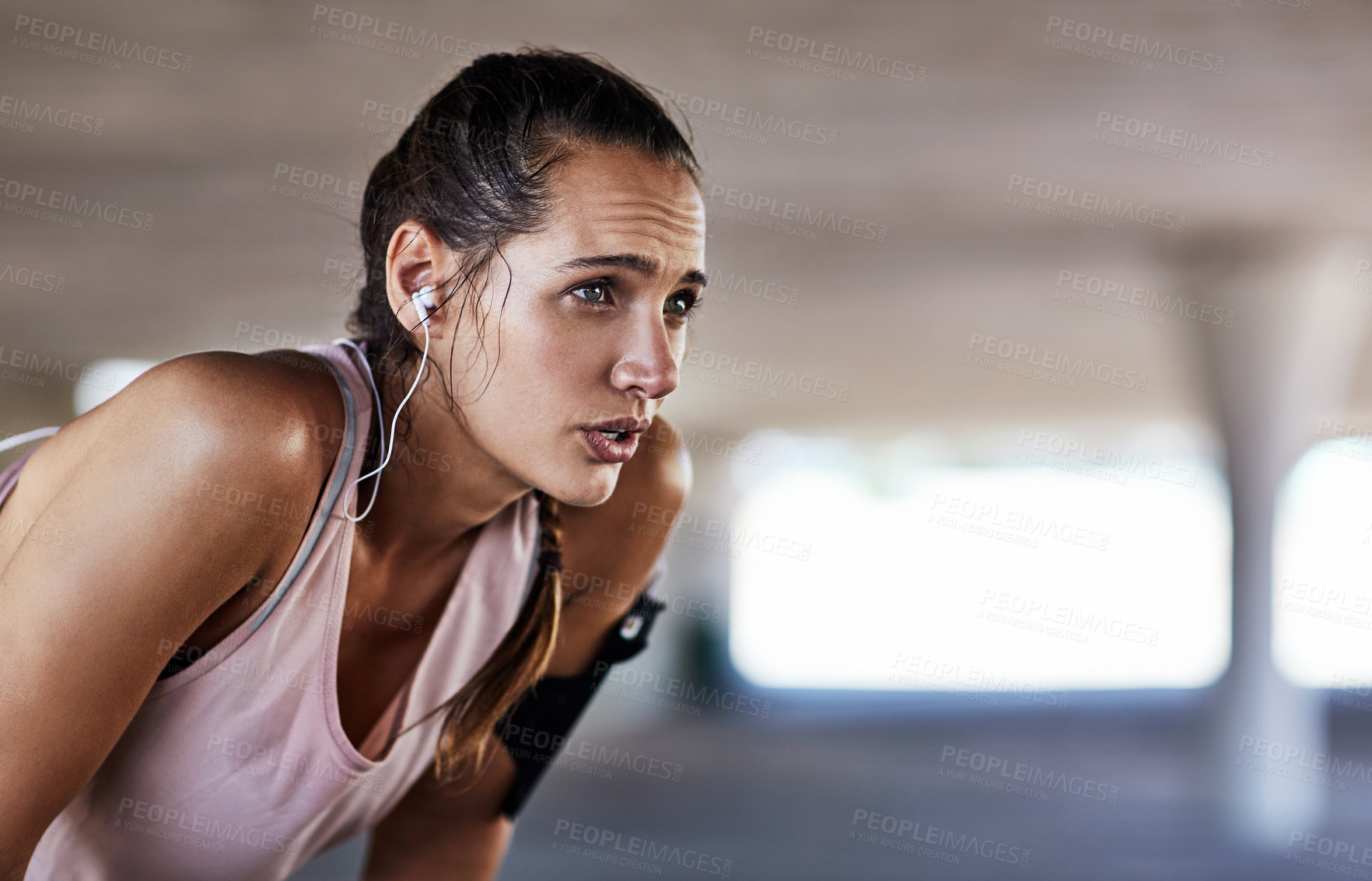 Buy stock photo Earphones, girl and tired in parking lot for fitness, catch breath and exercise break with music. Underground, runner or reflection with tech for wellness, workout fatigue or cardio tips in audio
