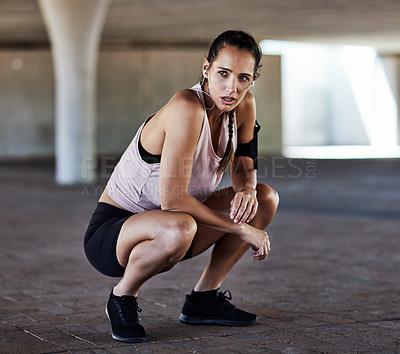 Buy stock photo Full length shot of an attractive young female athlete resting during her workout in the city