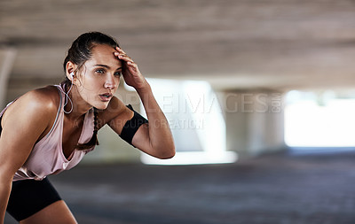 Buy stock photo Cropped shot of an attractive young female athlete resting during her workout in the city