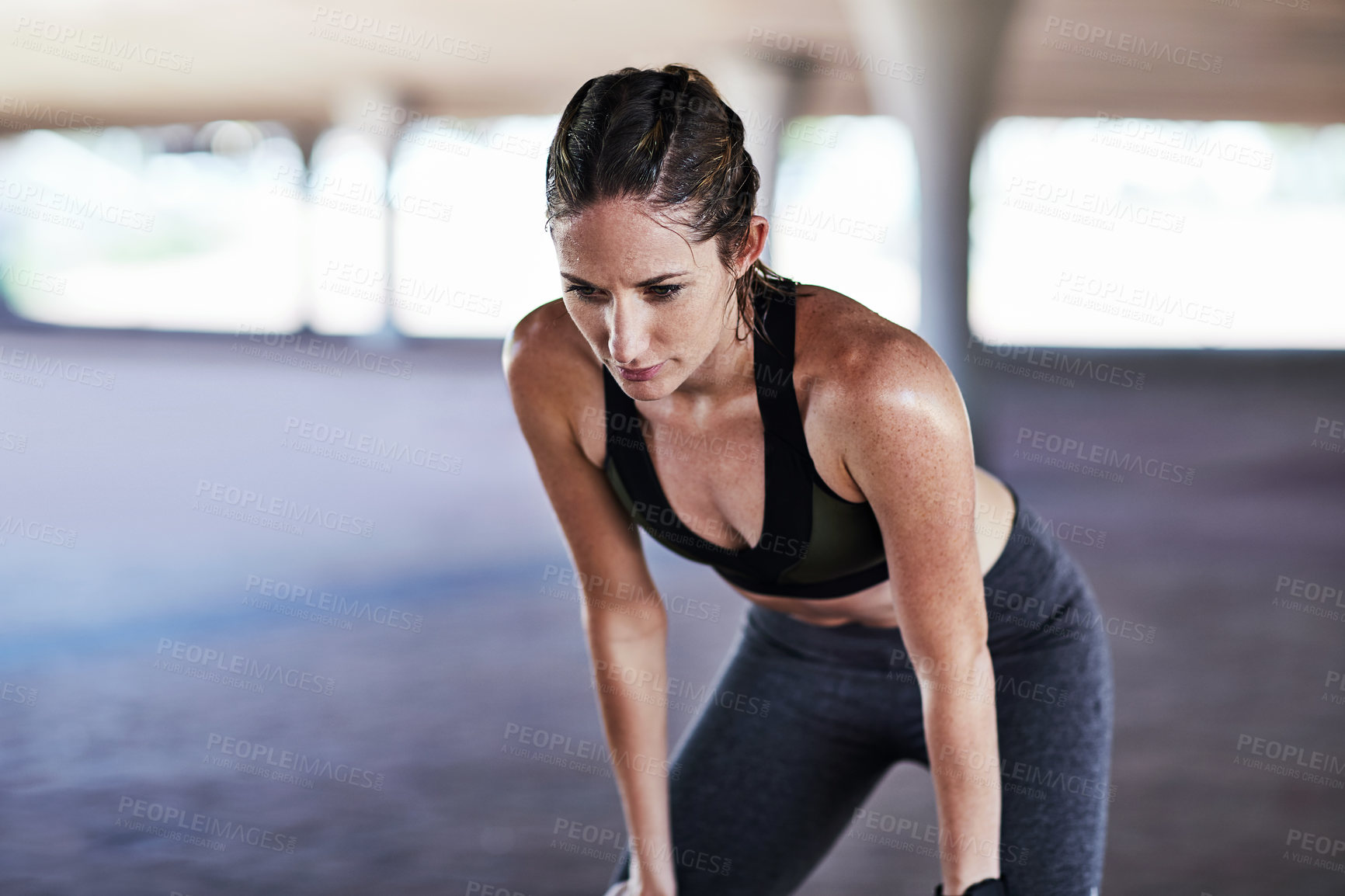 Buy stock photo Cropped shot of an attractive young female athlete resting during her workout in the city