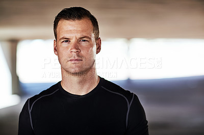Buy stock photo Cropped portrait of a handsome young male athlete working out in the city