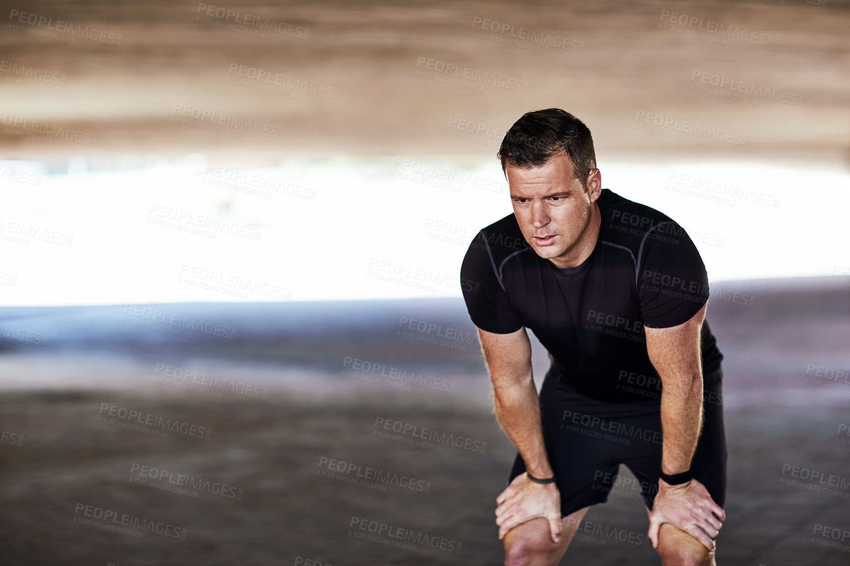 Buy stock photo Full length shot of a handsome young male athlete resting while working out in the city