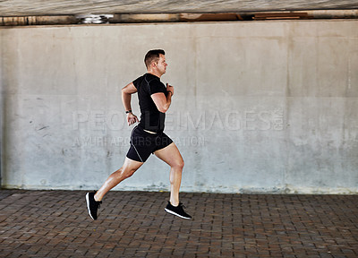 Buy stock photo Full length shot of a handsome young male athlete working out in the city