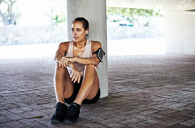 Buy stock photo Full length shot of an attractive young female athlete resting during her workout in the city