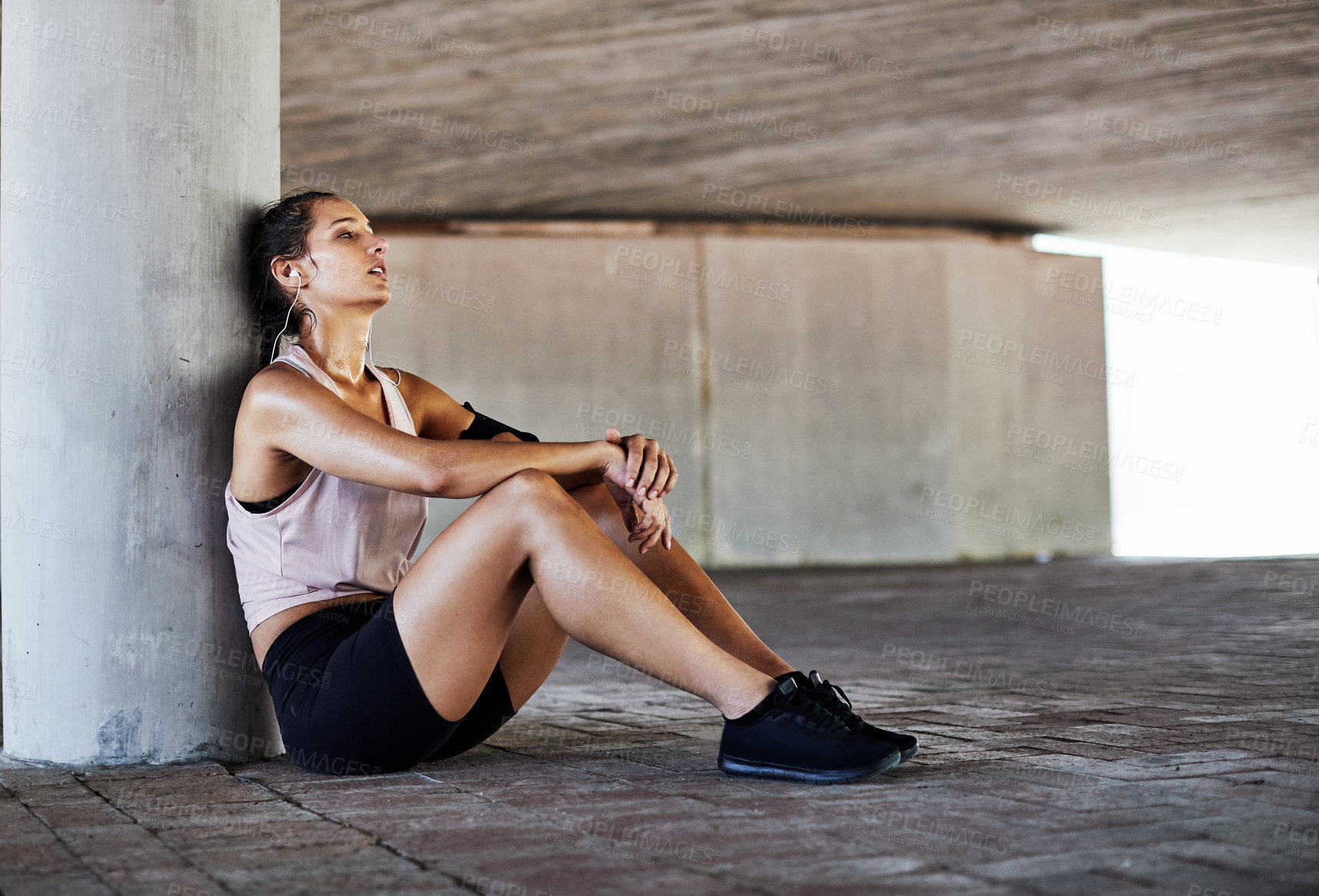 Buy stock photo Full length shot of an attractive young female athlete resting during her workout in the city
