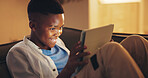 Smile, tablet and gamer with black child on sofa in home for esports app, streaming service and night. Online gaming platform, relax and entertainment with kid in living room of apartment for hobby