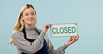 Closed, sulking and portrait of woman as cafe owner in studio for failure, announcement or signage. Sad, disappointed and message for bankruptcy, store or waitress with poster on blue background