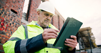 Buy stock photo Serious, civil engineer and man with tablet on construction site, online and planning for renovation. Architect, low angle and mature person with technology, research or info for property development