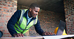 Architect, man and research with laptop in building, renovation or planning for property development. Project, online and black person with blueprint, design and civil engineering with technology