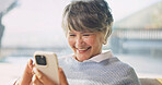 Phone, happy and senior woman in home with texting, email or communication on mobile app. Laugh, relax and elderly person with cellphone for contact, research or reading blog on website in house.