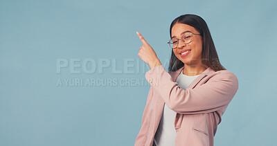 Buy stock photo Smile, business and woman point in studio, advertising and announcement for job interview. Portrait, mockup space or happy with person, b2b sign up and hand gesture for recruitment on blue background