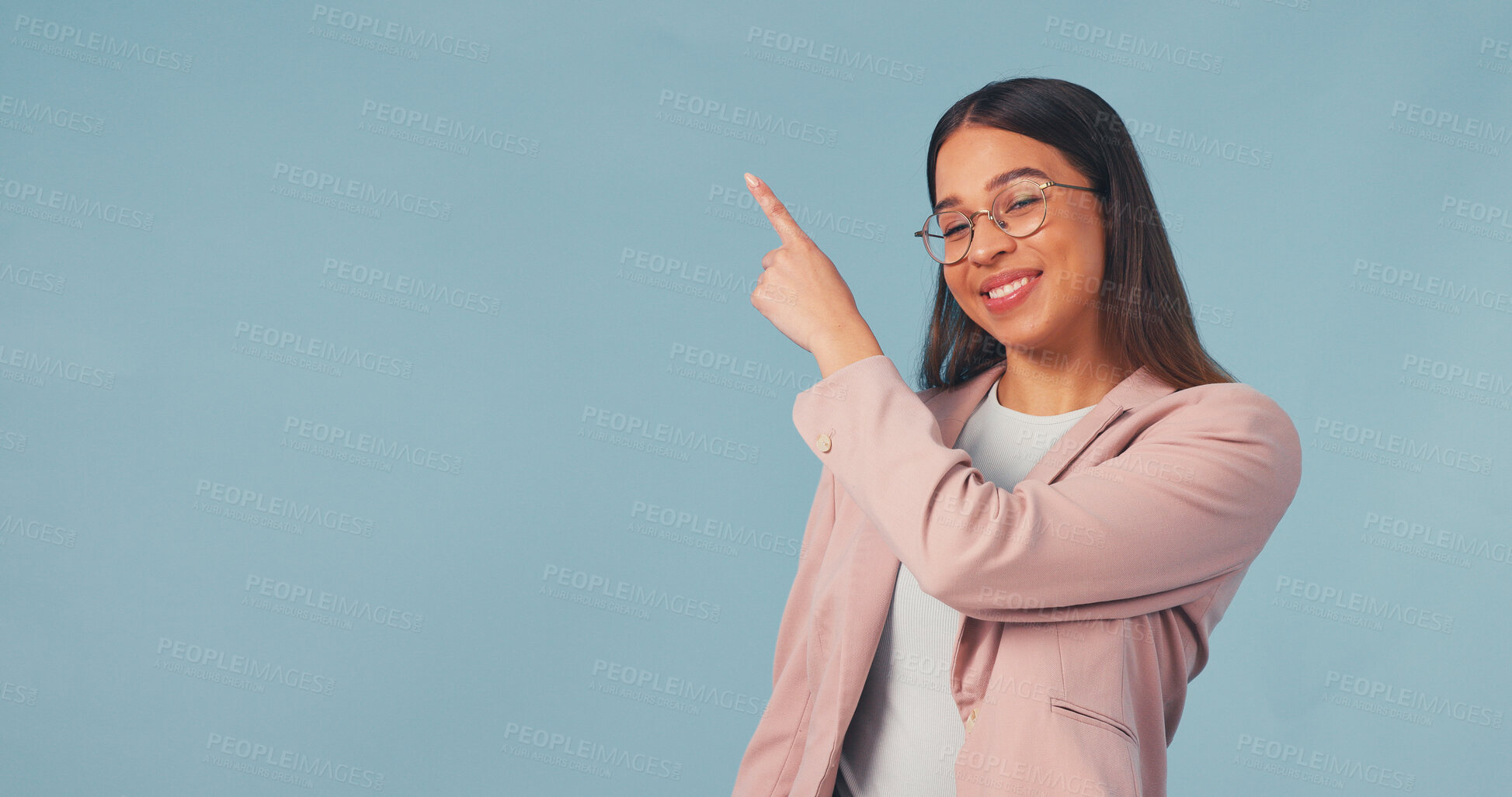 Buy stock photo Smile, business and woman point in studio, advertising and announcement for job interview. Portrait, mockup space or happy with person, b2b sign up and hand gesture for recruitment on blue background