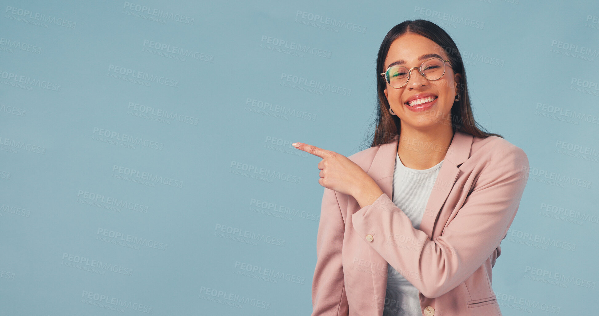 Buy stock photo Happy, business and woman point in studio, advertising and announcement for job interview. Portrait, mockup space or smile with person, b2b sign up and hand gesture for recruitment on blue background