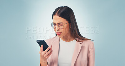 Buy stock photo Confused, businesswoman and reading in studio with phone, online glitch or notification of email scam. Space, person and concern with tech, suspicious text message or digital spam on blue background.