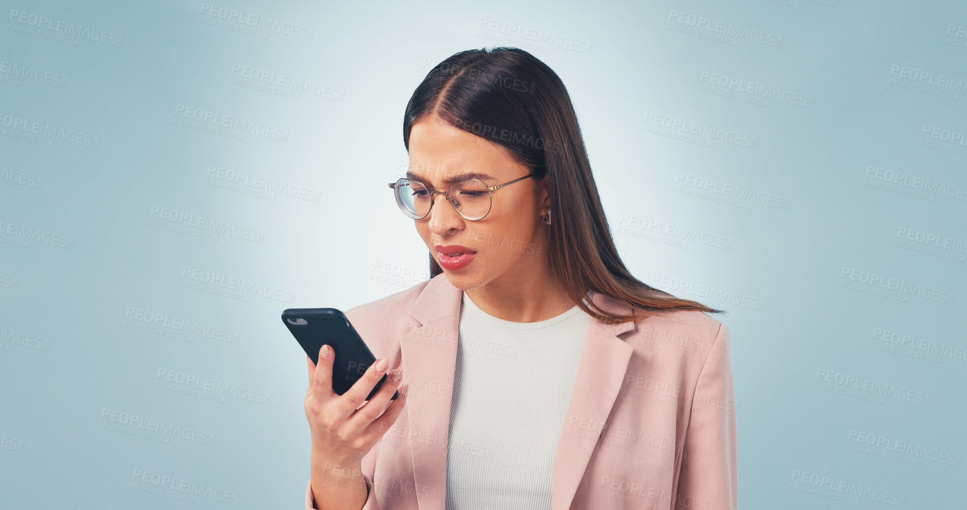 Buy stock photo Confused, businesswoman and reading in studio with phone, online glitch or notification of email scam. Space, person and concern with tech, suspicious text message or digital spam on blue background.