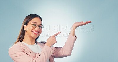 Buy stock photo Portrait, business and woman point in studio, advertising and news for product placement. Smile, space and female person with palm gesture, application and opinion for brand launch on blue background
