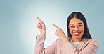 Portrait, woman and pointing in studio with smile, advertising and announcement for interview. Excited, mockup space or person with gesture, application and opinion for recruitment on blue background