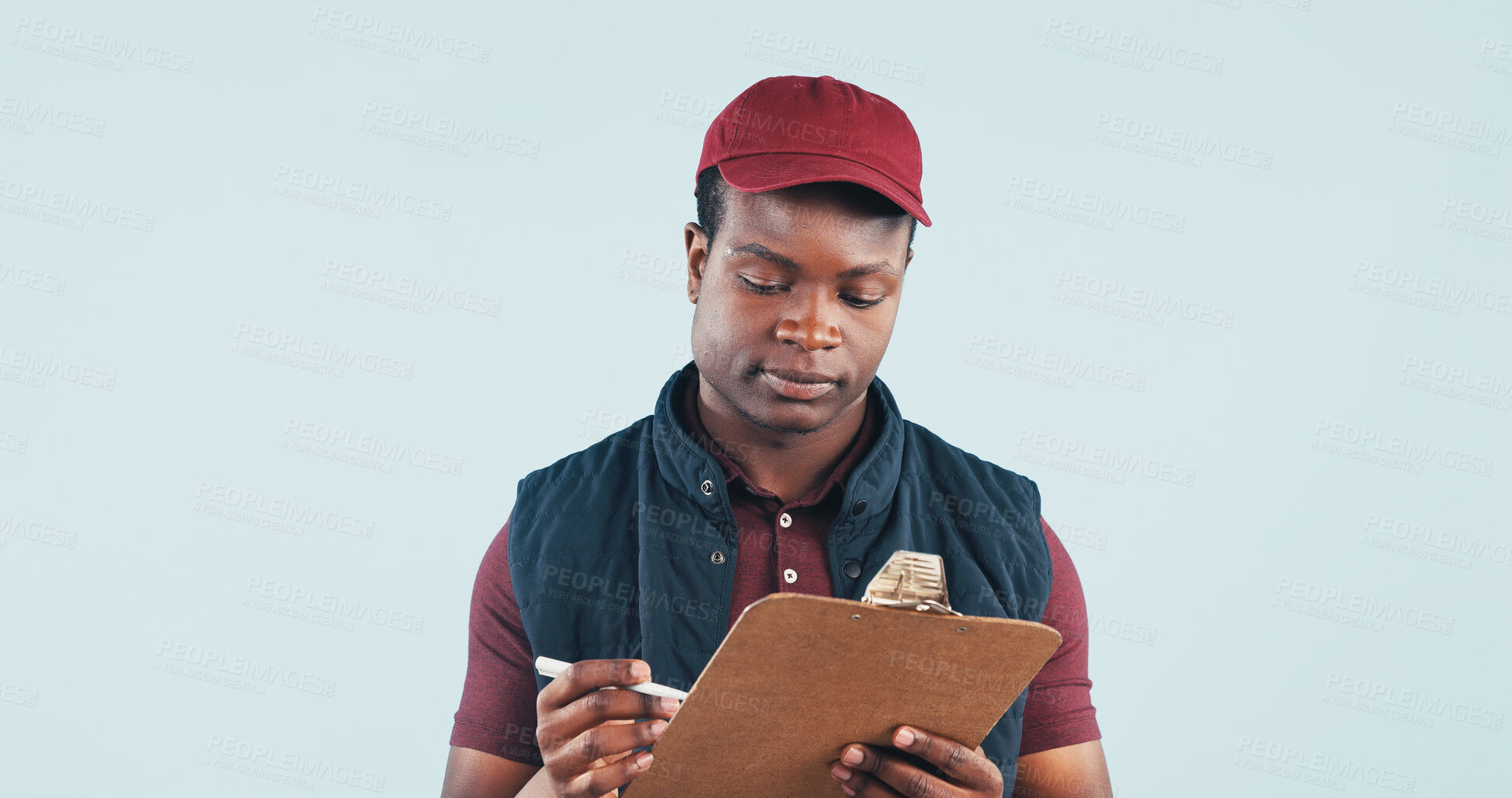 Buy stock photo Logistics, clipboard and delivery man reading in studio with receipt, postal service or customer order. Space, black person and courier with checklist, distribution and shipping on blue background.