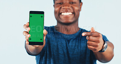 Buy stock photo Black man, phone and green screen in studio with pointing for app, fitness or social media. Mockup space, hand gesture and happy person with tech for promotion or exercise program on white background