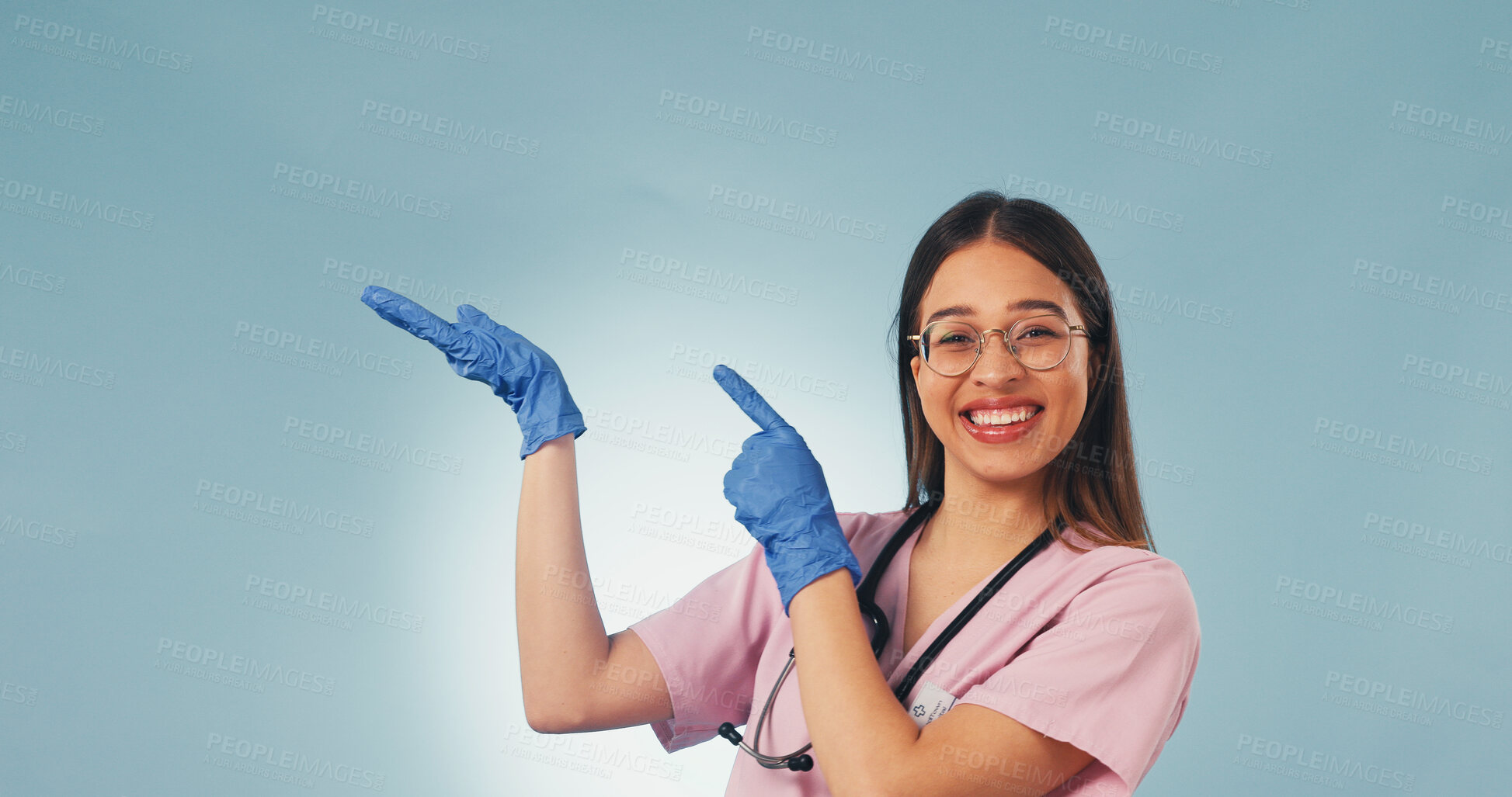 Buy stock photo Happy, portrait and nurse in studio pointing for health news, announcement and medical service. Mockup, space and woman with gesture for healthcare, wellness tips and clinic info on blue background