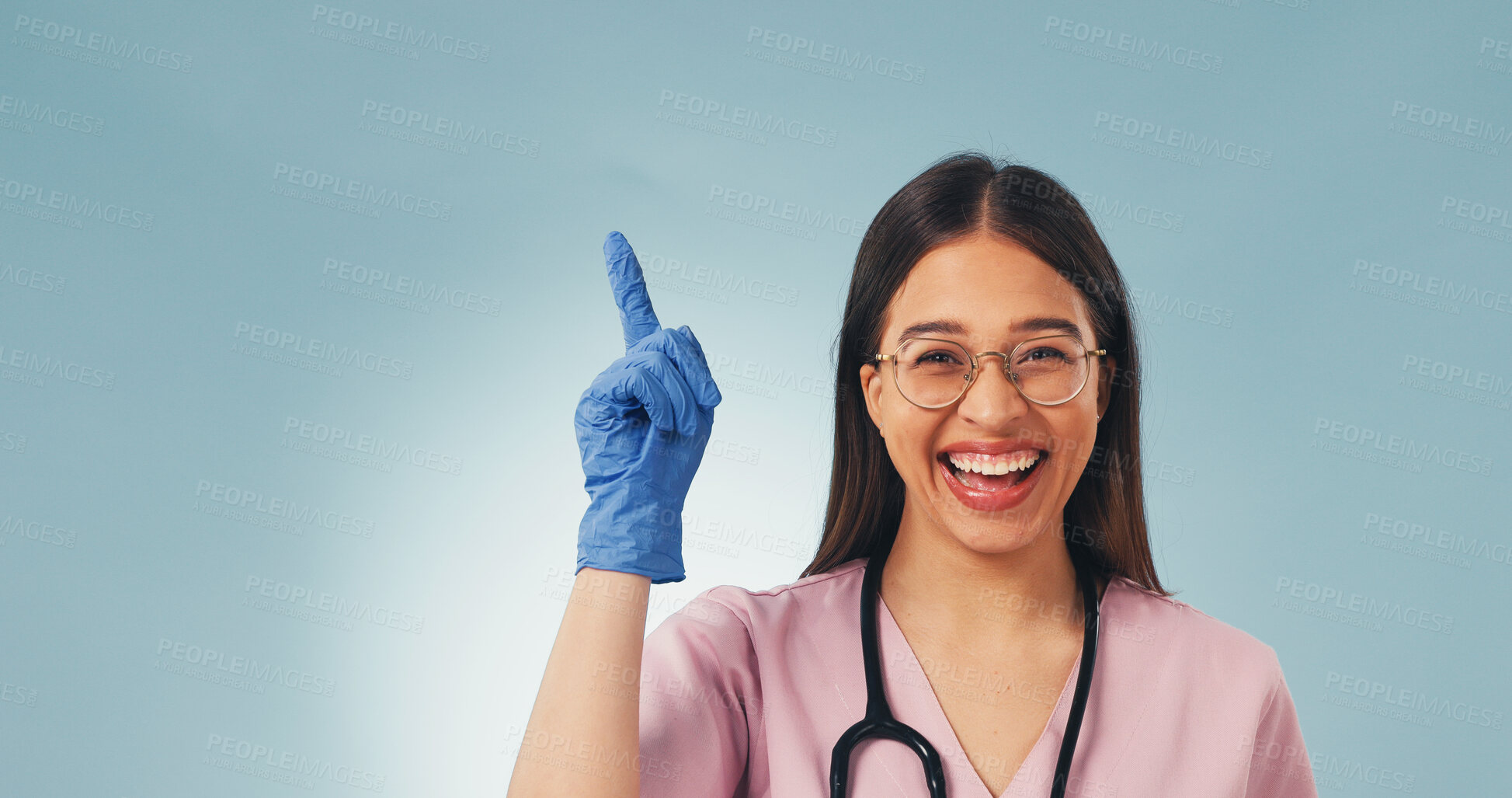 Buy stock photo Laugh, portrait and nurse in studio pointing for health news, announcement and medical service. Mockup, space and happy woman with gesture for healthcare, wellness tips and info on blue background