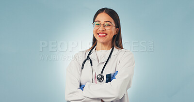 Buy stock photo Healthcare, doctor and happy woman in studio with arms crossed, portrait and space on blue background. Smile, confidence and medical worker with career integrity, about us and pride for wellness