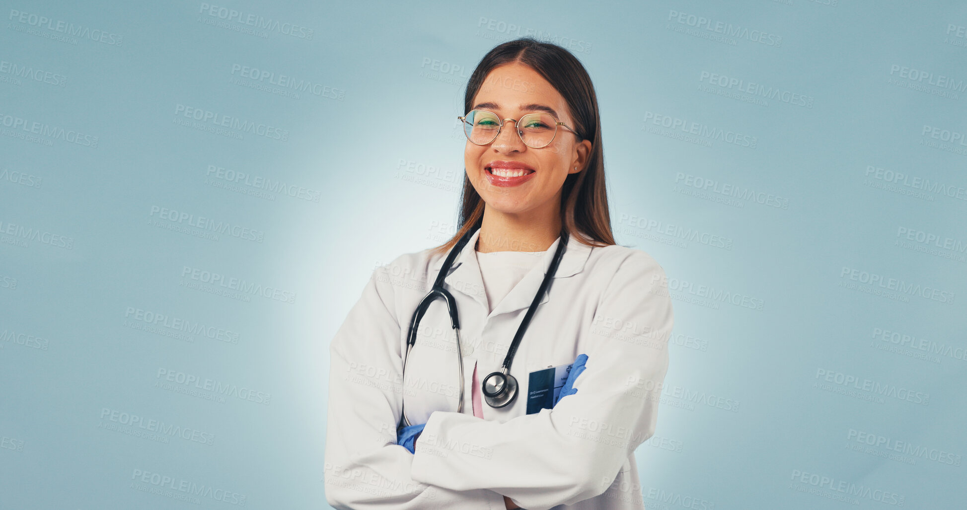 Buy stock photo Healthcare, doctor and happy woman in studio with arms crossed, portrait and space on blue background. Smile, confidence and medical worker with career integrity, about us and pride for wellness