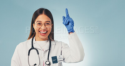 Buy stock photo Doctor, pointing and happy woman in studio, marketing and advice for healthcare service or portrait. Blue background, medical expert and person with advertising, space or laughing for health options