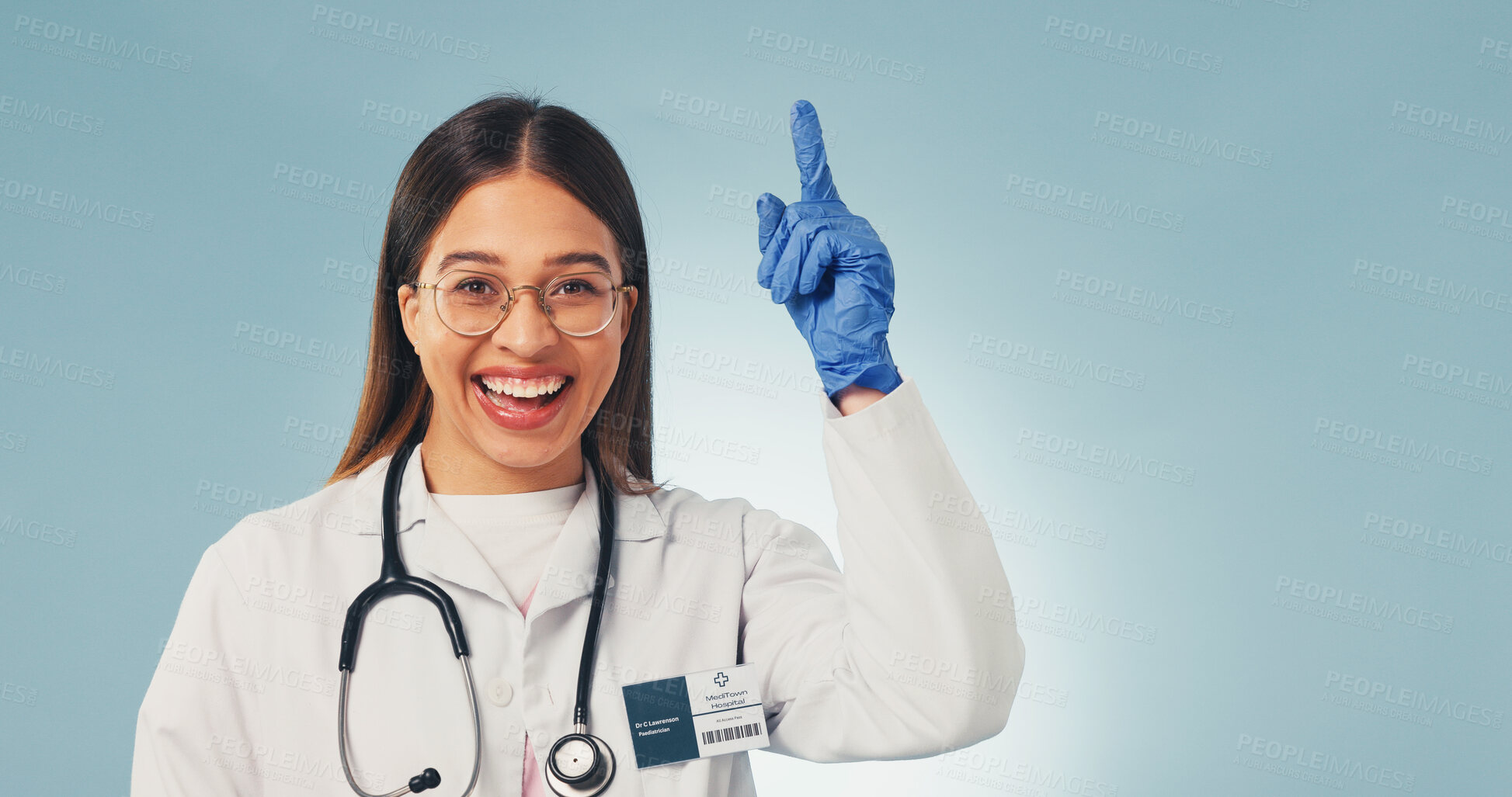 Buy stock photo Doctor, pointing and happy woman in studio, marketing and advice for healthcare service or portrait. Blue background, medical expert and person with advertising, space or laughing for health options