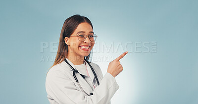 Buy stock photo Doctor, portrait and happy woman in studio, advertising and advice for healthcare services or point. Blue background, medical expert and person with smile, space and laughing with health options
