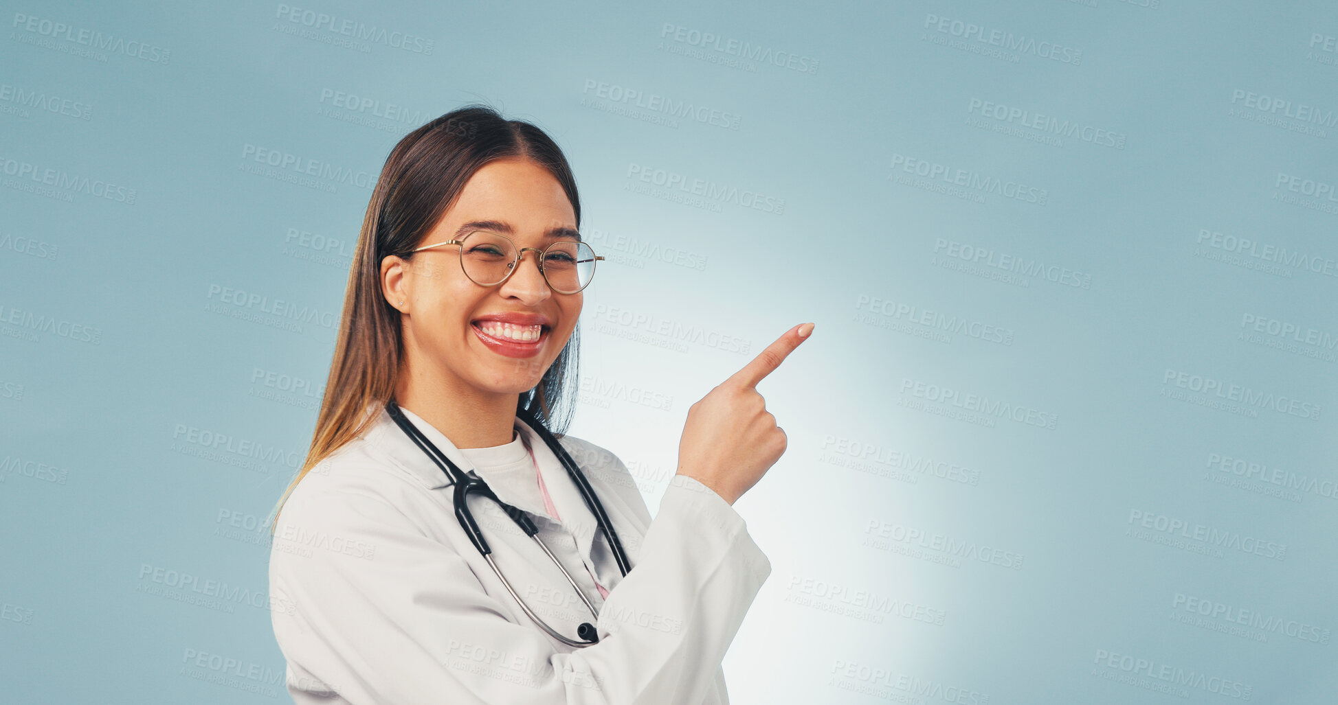Buy stock photo Doctor, portrait and happy woman in studio, point and recommendation for healthcare service or space. Blue background, medical expert and person with smile, presentation and advice for health options