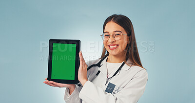 Buy stock photo Portrait, tablet and doctor in studio with green screen, mockup space or healthcare news. Happy, advertising and woman on tech for medical service, telehealth app and wellness info on blue background