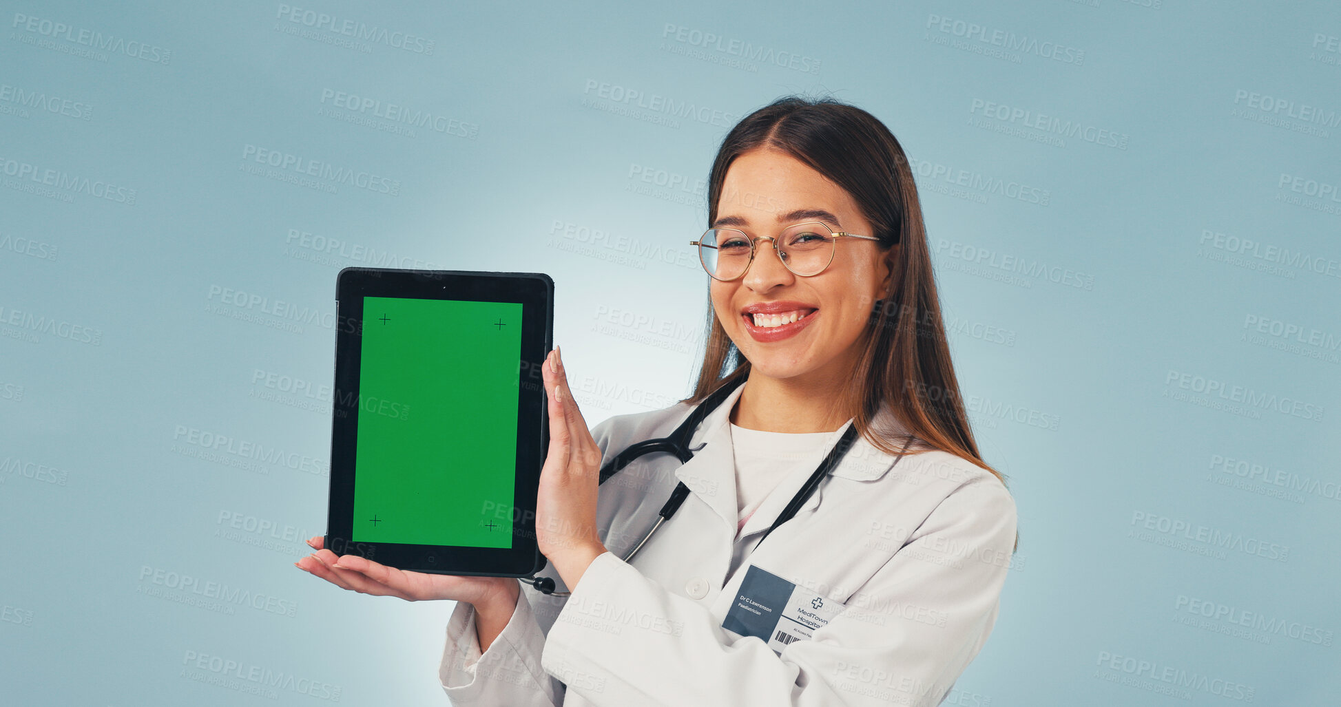 Buy stock photo Portrait, tablet and doctor in studio with green screen, mockup space or healthcare news. Happy, advertising and woman on tech for medical service, telehealth app and wellness info on blue background