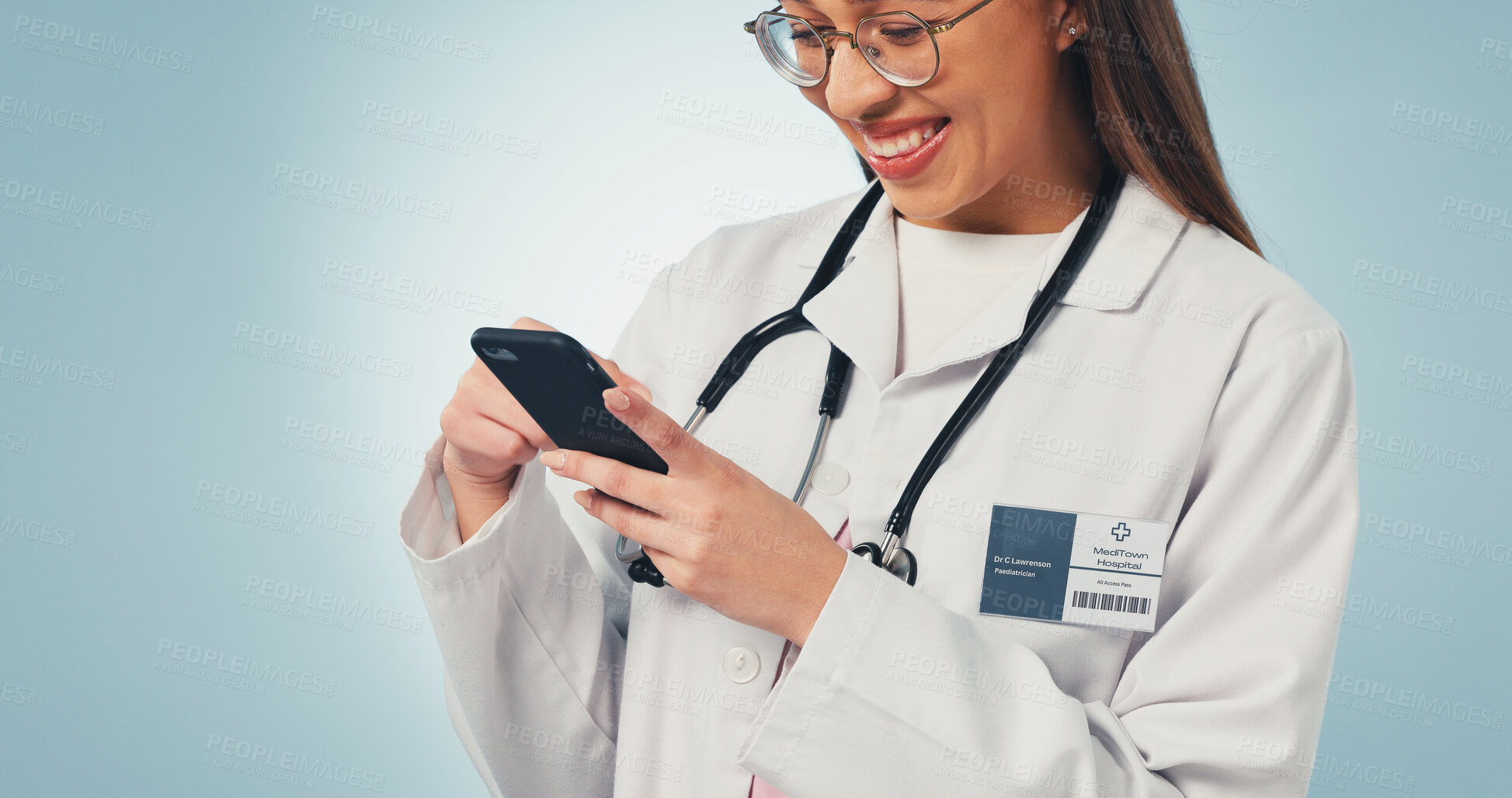 Buy stock photo Happy, scrolling and doctor with phone in studio with telehealth, consultation or texting on app. Smile, woman and healthcare worker with cellphone for medical research on blue background by space.