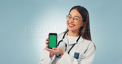 Buy stock photo Portrait, phone and doctor in studio with green screen, mockup space or healthcare news. Happy, advertising and woman on cellphone for medical service, telehealth and mobile app ux on blue background